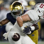 Stanford running back Casey Filkins, right, fumbles the ball next to Notre Dame safety Ramon Henderson during the first half of an NCAA college football game in South Bend, Ind., Saturday, Oct. 15, 2022. (AP Photo/Nam Y. Huh)
