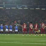 Players observe a minute of silence, in the memory of the fatal victims of a stampede during a soccer match in Indonesia, before the Champions League Group A soccer match between Liverpool and Rangers at Anfield stadium in Liverpool, England, Tuesday Oct. 4, 2022. (AP Photo/Rui Vieira)