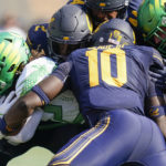 California safety Craig Woodson (2) and linebacker Oluwafemi Oladejo (10) tackle Oregon running back Noah Whittington, left, during the first half of an NCAA college football game in Berkeley, Calif., Saturday, Oct. 29, 2022. (AP Photo/Godofredo A. Vásquez)