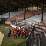 
              Cuban coaches dressed in orange, prepare a training session with the assistance of two foreign coaches dressed in gray, at the Pedro Marrero stadium in Havana, Cuba, Wednesday, Sept. 14, 2022. This initial group of 16 coaches was recently trained by international FIFA officials with the aim to create Cuba's next generation of professional soccer players on an island long known for birthing baseball and boxing superstars. (AP Photo/Ramon Espinosa)
            