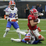 
              Georgia tight end Brock Bowers (19) is brought down after a reception by Florida safety Tre'Vez Johnson as safety Rashad Torrence II (22) during the first half of an NCAA college football game Saturday, Oct. 29, 2022, in Jacksonville, Fla. (AP Photo/John Raoux)
            