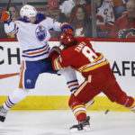 
              Edmonton Oilers' Warren Foegele, left, is hit by Calgary Flames' Chris Tanev during the first period of an NHL hockey game in Calgary, Alberta, Saturday, Oct. 29, 2022. (Larry MacDougal/The Canadian Press via AP)
            