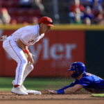 
              Cincinnati Reds' Spencer Steer, left, fields the ball as Chicago Cubs' Nico Hoerner steals second base during the second inning of a baseball game in Cincinnati, Friday, Wednesday, Oct. 5, 2022. (AP Photo/Aaron Doster)
            