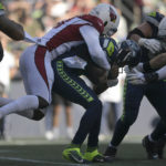 Arizona Cardinals linebacker Myjai Sanders, top, sacks Seattle Seahawks quarterback Geno Smith during the second half of an NFL football game in Seattle, Sunday, Oct. 16, 2022. (AP Photo/Caean Couto)