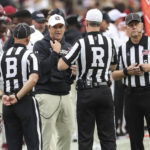 South Carolina head coach Shane Beamer, center left, talks with officials about a missed pass interference call during the first half of an NCAA college football game against Missouri, Saturday, Oct. 29, 2022, in Columbia, S.C. (AP Photo/Artie Walker Jr.)