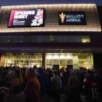 Arizona Coyotes fans wait for the doors to open prior to the Coyotes NHL home-opening game against the Winnipeg Jets at Mullett Arena in Tempe, Ariz., Friday, Oct. 28, 2022. For the Coyotes, the Mullett Arena is their temporary home they will share with the Arizona State NCAA college hockey team. (AP Photo/Ross D. Franklin)