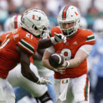 
              Miami quarterback Tyler Van Dyke (9) hands off to running back Henry Parrish Jr. (21) during the first half of an NCAA college football game against North Carolina, Saturday, Oct. 8, 2022, in Miami Gardens, Fla. (AP Photo/Wilfredo Lee)
            