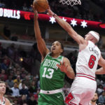 Chicago Bulls' Alex Caruso (6) blocks the shot of Boston Celtics' Malcolm Brogdon during the first half of an NBA basketball game Monday, Oct. 24, 2022, in Chicago. (AP Photo/Charles Rex Arbogast)