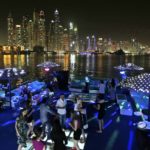 
              FILE - Guests dance on the GuGu boat during a private party with the skyline of the Marina Waterfront in Dubai, United Arab Emirates, on April 22, 2015. The FIFA World Cup may be bringing as many as 1.2 million fans to Qatar, but the nearby flashy emirate of Dubai is also looking to cash in on the major sports tournament taking place just a short flight away. (AP Photo/Kamran Jebreili, File)
            
