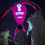 
              People take photos with the official FIFA World Cup Countdown Clock on Doha's corniche, in Qatar, Friday, Oct. 14, 2022. (AP Photo/Nariman El-Mofty)
            