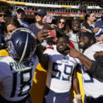 Tennessee Titans wide receiver Kyle Philips (18) defensive tackle Sam Okuayinonu (59) and tight end Chigoziem Okonkwo (85) celebrate with fans after an NFL football game against the Washington Commanders, Sunday, Oct. 9, 2022, in Landover, Md. Tennessee won 21-17. (AP Photo/Alex Brandon)