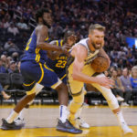 Sacramento Kings forward Domantas Sabonis (10) drives to the basket against Golden State Warriors forward Andrew Wiggins (22) during the first half of an NBA basketball game on Sunday, Oct. 23, 2022 in San Francisco. (AP Photo/Tony Avelar)