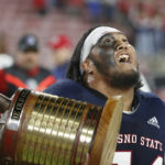 Fresno State offensive lineman Bula Schmidt shows off the Old Oil Can trophy after a come-from-behind win against San Diego State during the second half of an NCAA college football game in Fresno, Calif., Saturday, Oct. 29, 2022. (AP Photo/Gary Kazanjian)