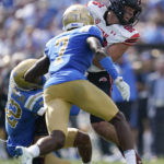 
              Utah tight end Dalton Kincaid (86) is tackled by UCLA defensive back William Nimmo Jr. (32) and defensive back Mo Osling III (7) during the first half of an NCAA college football game in Pasadena, Calif., Saturday, Oct. 8, 2022. (AP Photo/Ashley Landis)
            