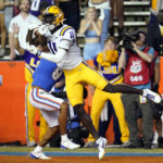 LSU wide receiver Brian Thomas Jr. (11) makes a reception on a 24-yard touchdown pass over Florida cornerback Jalen Kimber, center left, during the first half of an NCAA college football game, Saturday, Oct. 15, 2022, in Gainesville, Fla. (AP Photo/John Raoux)