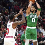 Boston Celtics' Jayson Tatum (0) shoots as Chicago Bulls' Coby White defends during the first half of an NBA basketball game Monday, Oct. 24, 2022, in Chicago. (AP Photo/Charles Rex Arbogast)