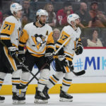 Pittsburgh Penguins right wing Bryan Rust (17) celebrates his goal with Kris Letang (58) and Evgeni Malkin (71) during the first period of a preseason NHL hockey game against the Detroit Red Wings Monday, Oct. 3, 2022, in Detroit. (AP Photo/Paul Sancya)