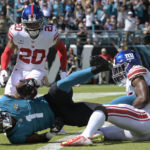 
              Jacksonville Jaguars running back Travis Etienne Jr. (1) scores past New York Giants safety Julian Love (20) and safety Xavier McKinney (29) on a 7-yard touchdown run during the first half of an NFL football game Sunday, Oct. 23, 2022, in Jacksonville, Fla. (AP Photo/Phelan M. Ebenhack)
            
