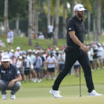 Cameron Smith, left, and Dustin Johnson, right, line up their shots on the second green during the final round of the LIV Golf Team Championship at Trump National Doral Golf Club, Sunday, Oct. 30, 2022, in Doral, Fla. (AP Photo/Lynne Sladky)