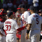 
              St. Louis Cardinals manager Oliver Marmol (37) talks with starting pitcher Adam Wainwright (50) as Marmol prepares to remove Wainwright along with catcher Yadier Molina, left, and first baseman Albert Pujols (5) at the same time during the fifth inning of a baseball game against the Pittsburgh Pirates Sunday, Oct. 2, 2022, in St. Louis. (AP Photo/Jeff Roberson)
            