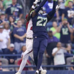 Seattle Seahawks cornerback Tariq Woolen (27) intercepts a pass intended for Arizona Cardinals wide receiver Marquise Brown, rear, during the second half of an NFL football game in Seattle, Sunday, Oct. 16, 2022. (AP Photo/Abbie Parr)