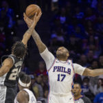 
              San Antonio Spurs guard Devin Vassell (24) and Philadelphia 76ers forward P.J. Tucker (17) reach for the ball in the first half of an NBA basketball game, Saturday, Oct. 22, 2022, in Philadelphia. (AP Photo/Laurence Kesterson)
            
