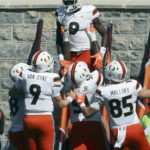 Miami's Frank Ladson (8) celebrates with teammates catching a touchdown pass during the first half during the first half of an NCAA football game against Virginia Tech, Saturday Oct. 15 2022,  in Blacksburg Va. (Matt Gentry/The Roanoke Times via AP)
