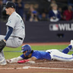 
              Toronto Blue Jays' Santiago Espinal scores on passed ball as Seattle Mariners relief pitcher Paul Sewald runs to cover the plate during the fifth inning of Game 2 of a baseball AL wild-card playoff series Saturday, Oct. 8, 2022, in Toronto. (Frank Gunn/The Canadian Press via AP)
            