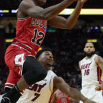 Chicago Bulls guard Ayo Dosunmu (12) drives to the basket over Miami Heat guard Kyle Lowry (7) during the first half of an NBA game Wednesday, Oct. 19, 2022, in Miami. (AP Photo/Marta Lavandier)
