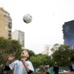 A child plays with a ball in front of a mural of Diego Maradona by artist Martin Ron in Buenos Aires, Argentina, Sunday, Oct. 30, 2022. Sunday marks the birth date of Maradona who died on Nov. 25, 2020 at the age of 60.(AP Photo/Rodrigo Abd)