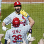 St. Louis Cardinals' Albert Pujols, top, celebrates with Juan Yepez as he heads to the dugout after he hit home run No. 703 in his career during the fifth inning of a baseball game against the Pittsburgh Pirates, Monday, Oct. 3, 2022, in Pittsburgh. (AP Photo/Keith Srakocic)