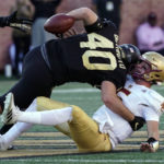 
              Boston College quarterback Phil Jurkovec (5) fumbles the ball as he is hit by Wake Forest defensive lineman Rondell Bothroyd (40) during the first half of an NCAA college football game in Winston-Salem, N.C., Saturday, Oct. 22, 2022. Boston College recovered the ball. (AP Photo/Chuck Burton)
            