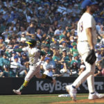 Oakland Athletics' Nick Allen, left, rounds third after hitting a two-run home run as Seattle Mariners starting pitcher Robbie Ray, right, walks to the mound during the sixth inning of a baseball game, Sunday, Oct. 2, 2022, in Seattle. (AP Photo/Jason Redmond)