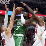 Chicago Bulls' Nikola Vucevic (9) and Patrick Williams pressure Boston Celtics' Jaylen Brown during the first half of an NBA basketball game Monday, Oct. 24, 2022, in Chicago. (AP Photo/Charles Rex Arbogast)