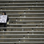 A lone fan sits in the empty student section late in the second half of an NCAA college football game as Colorado fell behind Arizona State, Saturday, Oct. 29, 2022, in Boulder, Colo. (AP Photo/David Zalubowski)