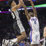 
              San Antonio Spurs guard Tre Jones (33) takes a shot over Philadelphia 76ers guard Tyrese Maxey (0) in the first half on an NBA basketball game, Saturday, Oct. 22, 2022, in Philadelphia. (AP Photo/Laurence Kesterson)
            