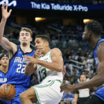 
              Boston Celtics' Malcolm Brogdon (13) loses the ball as he tries to go up to shoot between Orlando Magic's Franz Wagner (22) and Mo Bamba, right, during the first half of an NBA basketball game, Saturday, Oct. 22, 2022, in Orlando, Fla. (AP Photo/John Raoux)
            