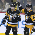 Pittsburgh Penguins' Jake Guentzel (59) is congratulated by Sidney Crosby after scoring against the Buffalo Sabres during the first period of an NHL preseason hockey game Friday, Oct. 7, 2022, in Pittsburgh. (AP Photo/Keith Srakocic)