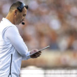 
              Texas head coach Steve Sarkisian checks his notes during the first half of the team's NCAA college football game against West Virginia on Saturday, Oct. 1, 2022, in Austin, Texas. (AP Photo/Stephen Spillman)
            