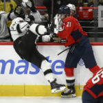 Washington Capitals right wing Garnet Hathaway (21) and Los Angeles Kings left wing Kevin Fiala (22) collide along the boards during the third period of an NHL hockey game, Saturday, Oct. 22, 2022, in Washington. (AP Photo/Nick Wass)