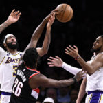 
              Los Angeles Lakers forward Anthony Davis, left, vies for the ball with Portland Trail Blazers forward Justise Winslow, center, and Lakers forward Troy Brown Jr., right, during the first half of an NBA basketball game Sunday, Oct. 23, 2022, in Los Angeles. (AP Photo/Alex Gallardo)
            