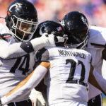 Cincinnati running back Ryan Montgomery (22) is congratulated by teammates after scoring a touchdown during the first half of an NCAA college football game against SMU, Saturday, Oct. 22, 2022, in Dallas. (AP Photo/Brandon Wade)