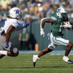 
              Tulane running back Shaadie Clayton (0) runs the ball past Memphis linebacker Tyler Murray (5) during the first half of an NCAA college football in New Orleans, Saturday, Oct. 22, 2022. (AP Photo/Tyler Kaufman)
            