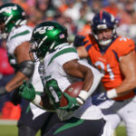 
              New York Jets running back Breece Hall (20) runs for the end zone against the Denver Broncos during the first half of an NFL football game, Sunday, Oct. 23, 2022, in Denver. Hall scored a touchdown on the play. (AP Photo/Matt York)
            