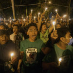 
              Soccer fans chant slogans during a candle light vigil for supporters of Arema FC who died in Saturday's stampede, in Medan, North Sumatra, Indonesia, Monday, Oct. 3, 2022. Indonesian police said they were investigating over a dozen officers responsible for firing tear gas that set off a crush that killed a number of people at a soccer match between Arema FC of Malang and Persebaya of neighboring Surabaya city, as families and friends grieved Monday for the victims that included children. (AP Photo/Binsar Bakkara)
            