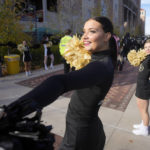 Colorado cheerleader Cami Daniels welcomes players as they arrive before an NCAA college football game against Arizona State, Saturday, Oct. 29, 2022, in Boulder, Colo. (AP Photo/David Zalubowski)