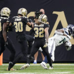 Seattle Seahawks wide receiver DK Metcalf, right, falls in the end zone for a touchdown off a pass from Geno Smith during an NFL football game against the New Orleans Saints in New Orleans, Sunday, Oct. 9, 2022. (AP Photo/Gerald Herbert)