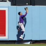 
              Colorado Rockies center fielder Yonathan Daza leaps at the wall to catch a fly ball by Los Angeles Dodgers' Cody Bellinger during the third inning of a baseball game Sunday, Oct. 2, 2022, in Los Angeles. Bellinger drove in a run with a sacrifice on the play. (AP Photo/Marcio Jose Sanchez)
            