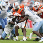 
              Miami running back Thaddius Franklin Jr., center, is taken down by North Carolina players during the first half of an NCAA college football game, Saturday, Oct. 8, 2022, in Miami Gardens, Fla. (AP Photo/Wilfredo Lee)
            