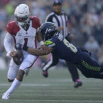 Arizona Cardinals quarterback Kyler Murray (1) fumbles while tackled by Seattle Seahawks cornerback Coby Bryant, right, during the second half of an NFL football game in Seattle, Sunday, Oct. 16, 2022. The ball was recovered by Seahawks cornerback Tariq Woolen. (AP Photo/Caean Couto)